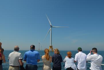 People look out at the Block Island Wind Farm off the coast of Rhode Island.