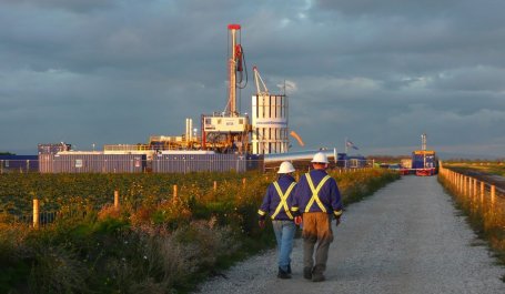 Two workers walking to a natural gas fracking operation. Photo by Justin Woolford/Flickr.