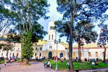 People sit outside a church in Bogota, Colombia