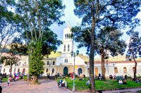 People sit outside a church in Bogota, Colombia