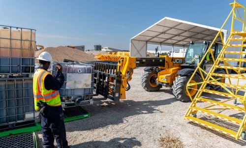 A man directs heavy equipment as part of Charm Industrial's bio-oil production.