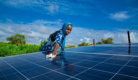 A woman cleans solar panels in Mauritania