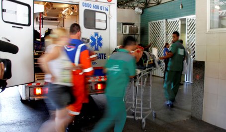 People rush from an ambulance into a hopsital.