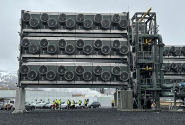Direct air capture units at a Climeworks facility in Iceland with snow-capped mountains in the background.