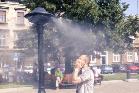 A man stands under a water spray.