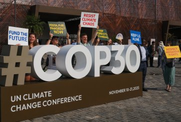 People hold signs protecting climate change outside of the UN climate summit venue.