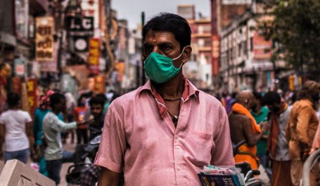 A man selling masks on a busy street in Varanasi, India.