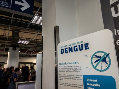 A sign warns passengers at an airport to the dangers of dengue fever.