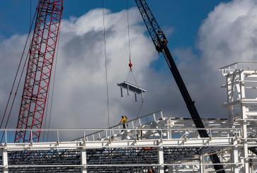 Scaffolding being constructed for a large industrial building.
