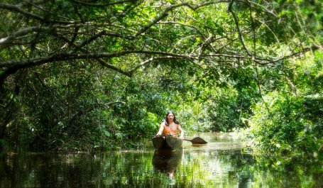 Man in a canoe in Ecuador's Amazon forest