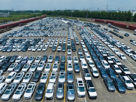 Many electric cars lined up on a lot for sale.