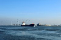 A ship passes by wind turbines in Rotterdam, Netherlands.