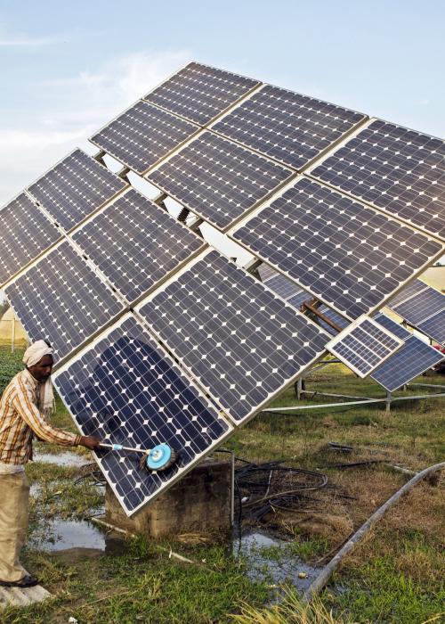 Farm worker clean the solar panels of a solar water pump at the farm.