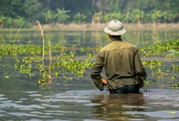 A farmer standing in a flooded field. 