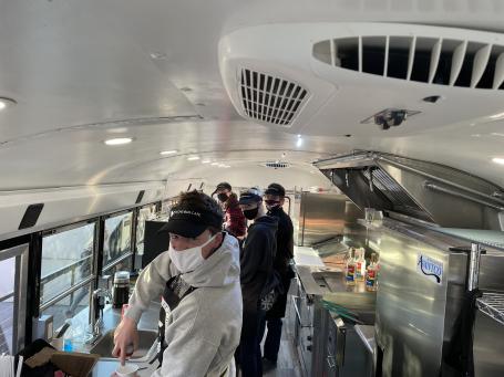 People working inside a bus converted into a coffee shop.