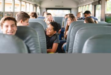Kids riding in the back of a school bus. 