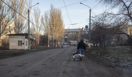 A man carries a cart in Bakhmut, Ukraine during the Russian invasion