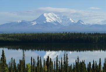 A snow-capped mountain reflection in a clear lake