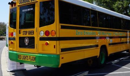 An electric school bus waiting in a parking lot. 