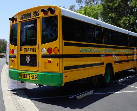 An electric school bus waiting in a parking lot. 