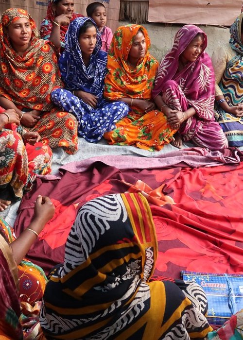 Women sit on ground discussing issues in Bangladesh