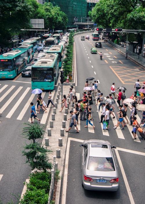 People on crosswalk across large street