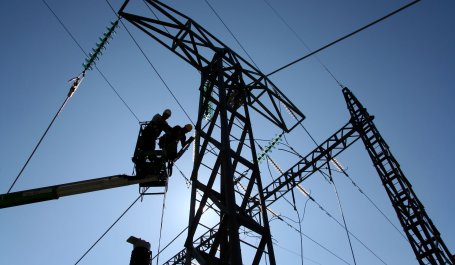 Two powerline workers in a lift. 