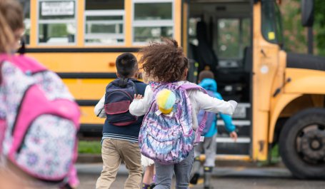Young children board a school bus