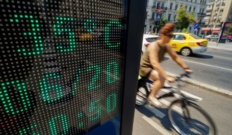 A person bicycles past a sign that reads 35 degrees Celsius.