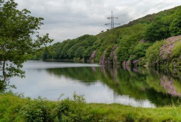 A manmade reservoir with powerlines in the background