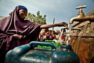 Habiba Hossen is collecting water from a rehabilitated distribution point in Kole Community.