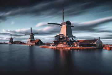 Windmills on small islands in a large body of water. 