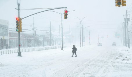 A  woman walks alone along a snow-covered street in New York City as Winter Storm Fern intensifies