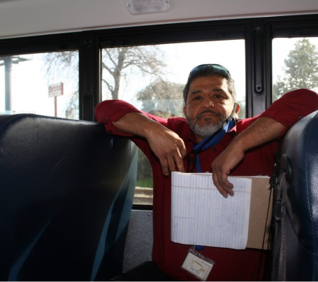 A man sitting in the back of a school bus. 